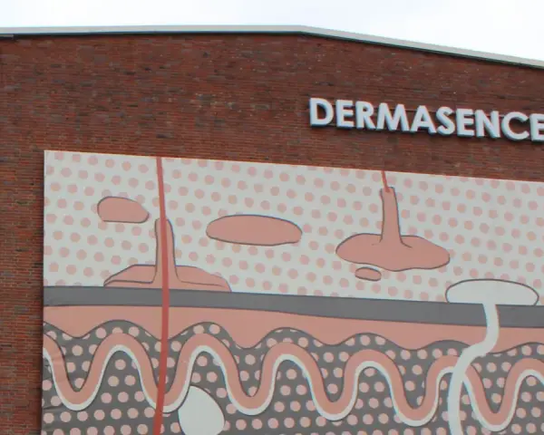 Gebäude mit Schriftzug DERMASENCE und einer Hautschichten-Grafik.