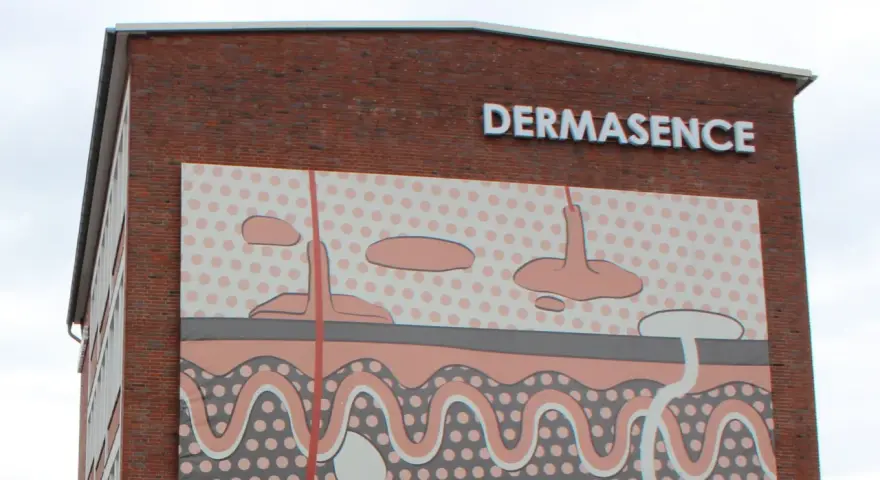 Gebäude mit Schriftzug DERMASENCE und einer Hautschichten-Grafik.