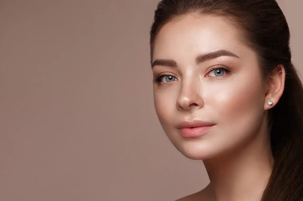 Frau trägt Lippenbalsam mit LSF auf, Schutz Permanent Make-up Lippen