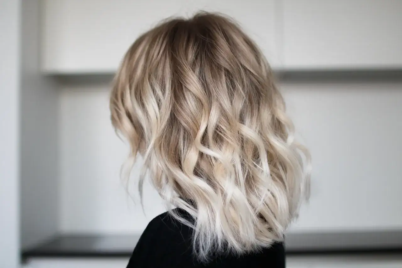 Frau stylt Beach Waves mit Glätteisen